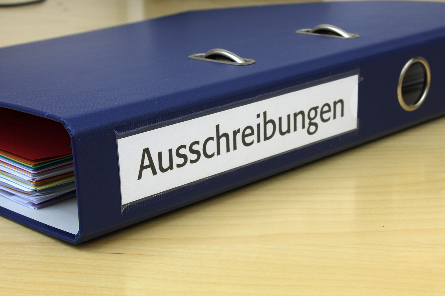 Blauer Ordner mit der Beschriftung Ausschreibungen
